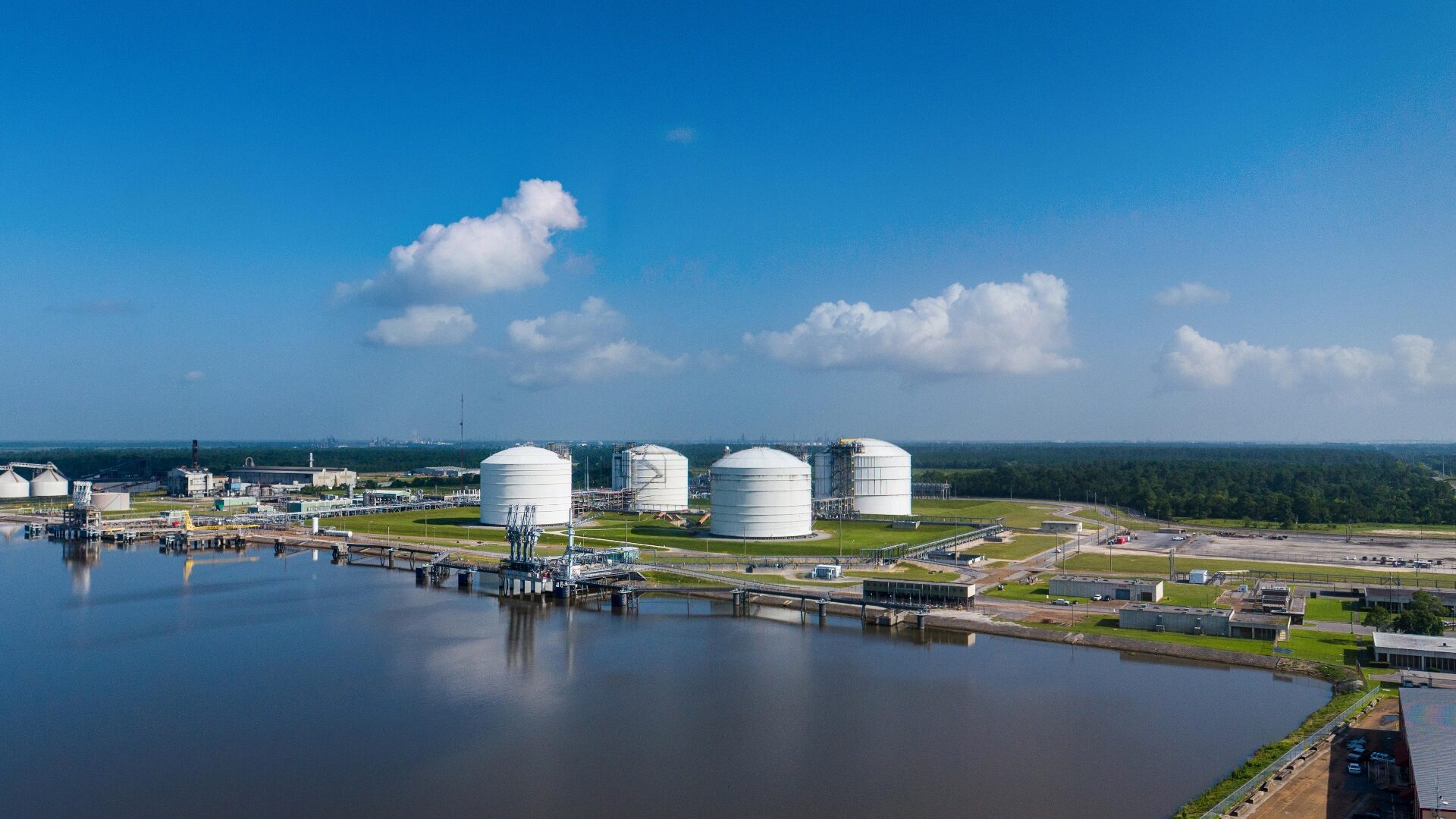 Aerial view of a US LNG export terminal with storage tanks and marine berths
